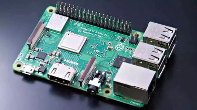 Placa Raspberry Pi 3 Model B+ con sus componentes, puertos USB, Ethernet y conectores GPIO a la vista sobre un fondo oscuro.