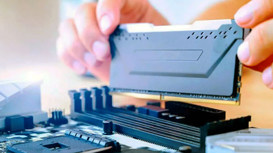 Técnico instalando un módulo de memoria RAM DDR5 en la ranura DIMM de una placa base de ordenador