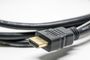 Conector HDMI de plástico negro con contactos dorados, conectado a cable flexible.
