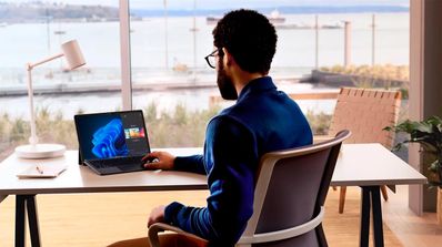Hombre utilizando portátil con Windows 11 sobre una mesa