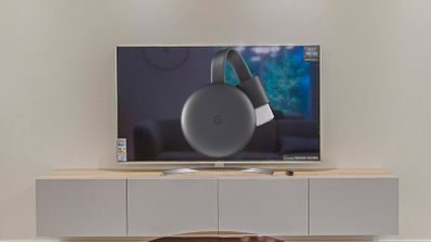 Chromecast de tercera generación sobre un fondo en el que se muestra una televisión.