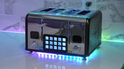 PC PC gaming de alto rendimiento montado dentro de una carcasa de tostadora cromada, con iluminación RGB visible en su interior.