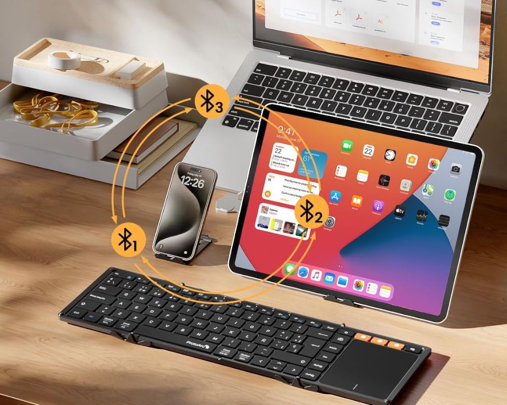 Teclado inalámbrico ProtoArc XK01 TP plegado en tres partes junto a un smartphone para mostrar su tamaño compacto y portabilidad.