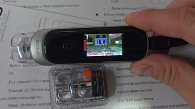 Primer plano de la pantalla LCD de un vaper Aspire PIXO mostrando el videojuego DOOM funcionando mediante streaming desde un PC.