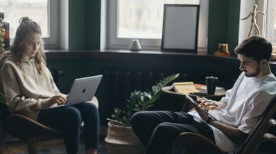 Mujer y hombre utilizando un iPad y un MacBook