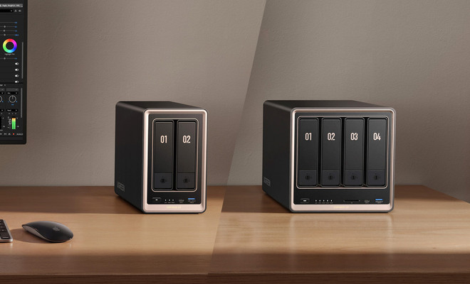 Dos unidades de almacenamiento NAS Ugreen NASync de dos y cuatro bahías sobre una mesa de madera.