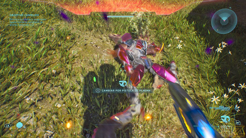 Vista en primera persona de un combate en Halo sobre terreno herboso con un enemigo caído y la opción de cambiar arma a pistola de plasma.