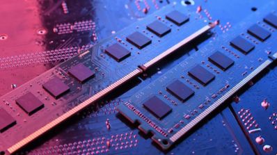 Dos módulos de memoria RAM DDR4 instalados sobre una placa base con iluminación ambiental azul y rosa.