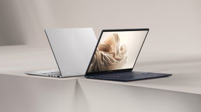 Dos ordenadores portátiles ASUS Zenbook 14 mostrados desde el frontal y la parte trasera sobre una superficie geométrica.