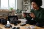 Mujer joven jugando con una consola Nintendo Switch rodeada de varios accesorios sobre una mesa de madera.