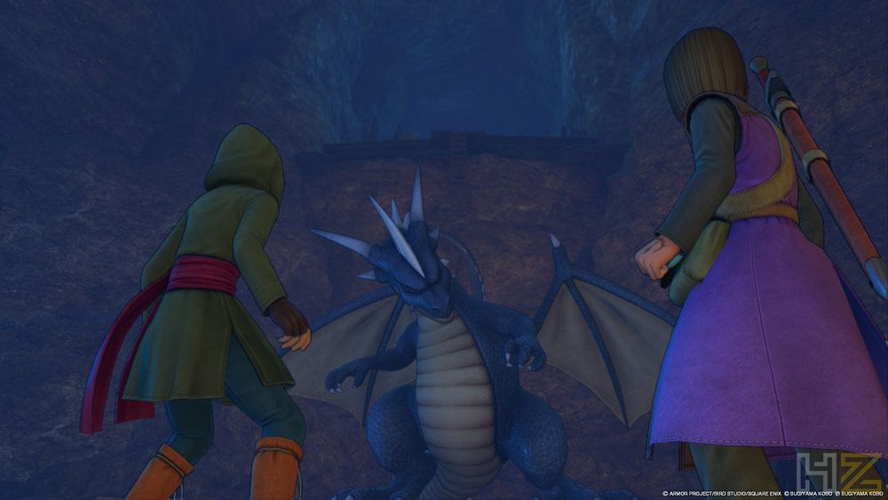 Dos personajes de Dragon Quest XI frente a un dragón azul en el interior de una cueva.