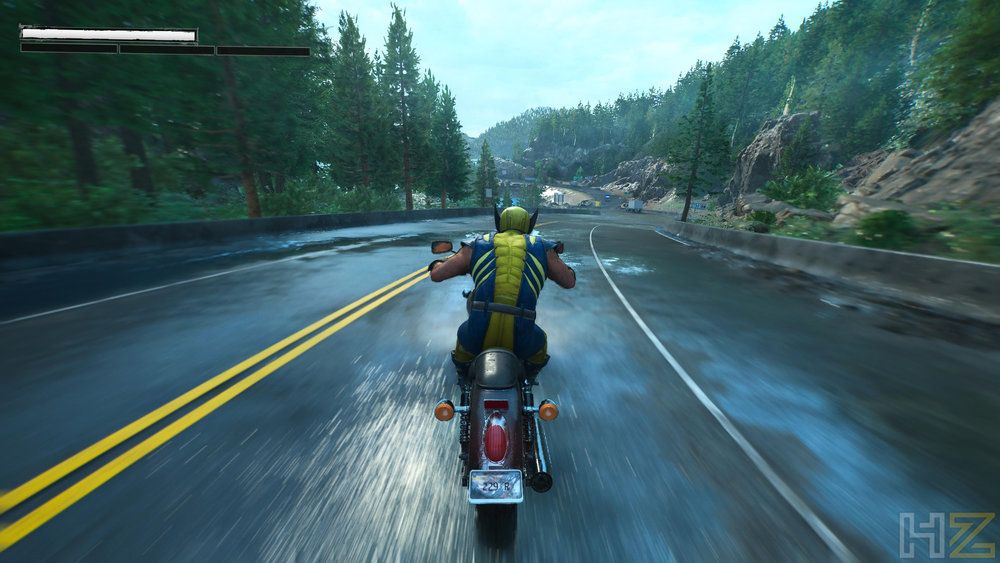 Perspectiva en tercera persona de Lobezno conduciendo una motocicleta por una carretera de montaña.
