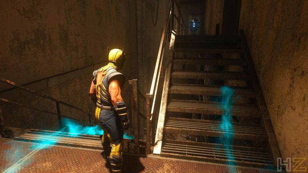Lobezno de espaldas frente a unas escaleras en un entorno industrial oscuro con rastros de energía azul.