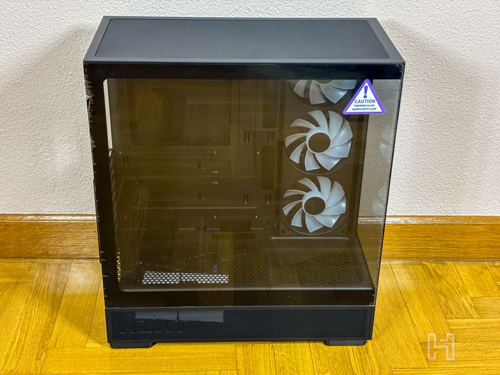 Caja de ordenador NZXT S5 RGB con paneles de cristal templado frontal y lateral sobre suelo de madera.