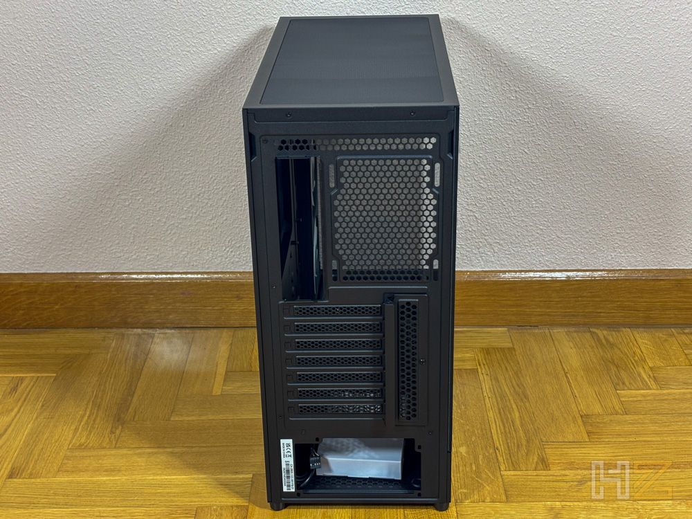Vista posterior de la caja de PC NZXT S5 RGB en color negro, mostrando las ranuras de expansión y el hueco para la fuente de alimentación.