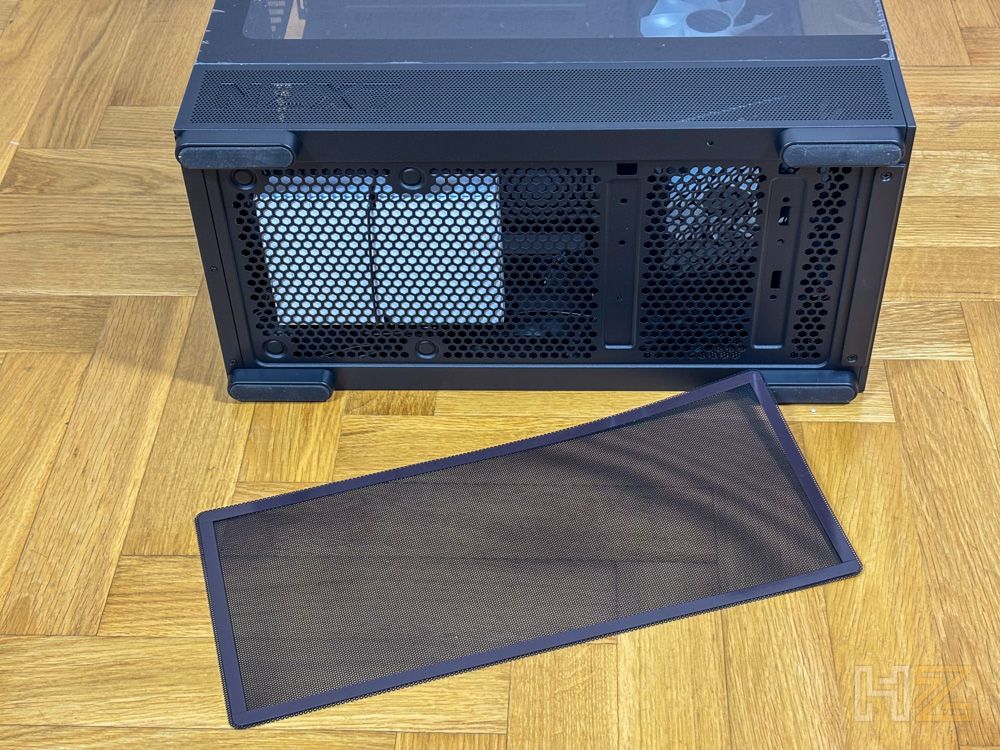Parte inferior de la caja NZXT S5 RGB con el filtro de polvo extraído sobre un suelo de madera.