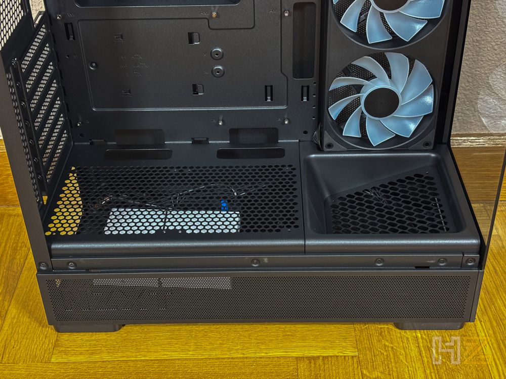 Interior inferior de la caja NZXT S5 RGB mostrando la cubierta de la fuente de alimentación con rejillas de ventilación y dos ventiladores frontales.