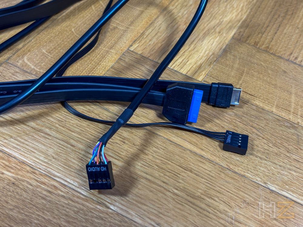 Conectores internos de una caja de PC NZXT S5 RGB, incluyendo HD Audio, USB y panel frontal sobre una superficie de madera.