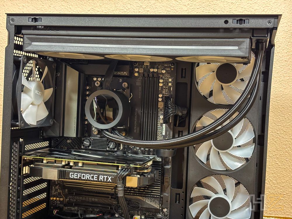 Interior de una caja de PC NZXT S5 RGB con tarjeta gráfica GeForce RTX y sistema de refrigeración líquida instalados.