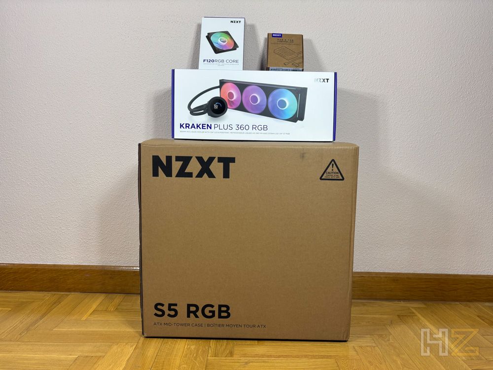 Caja de embalaje del chasis NZXT S5 RGB junto a otros componentes de hardware como una refrigeración líquida Kraken Plus 360 RGB.