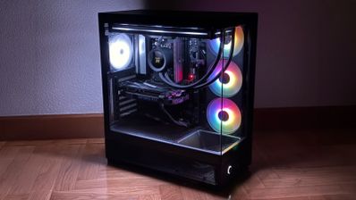 Ordenador de sobremesa NZXT S5 RGB con paneles de cristal templado y ventiladores iluminados funcionando en una habitación con poca luz.