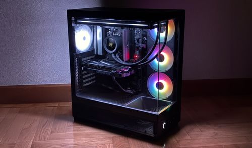 Ordenador de sobremesa NZXT S5 RGB con paneles de cristal templado y ventiladores iluminados funcionando en una habitación con poca luz.