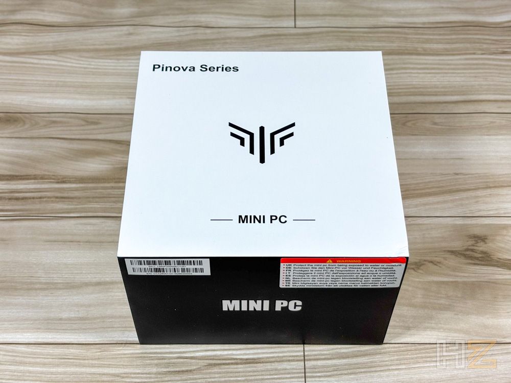 Caja de embalaje blanca y negra del ordenador compacto NiPoGi P2 Pinova Series sobre una mesa de madera.