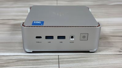 Panel frontal del mini PC NiPoGi P2 con puertos USB-C, USB-A y jack de audio sobre una superficie de madera.