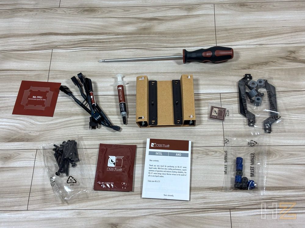 Accesorios y herramientas de montaje del kit Noctua NL-LC1 distribuidos sobre una superficie de madera.