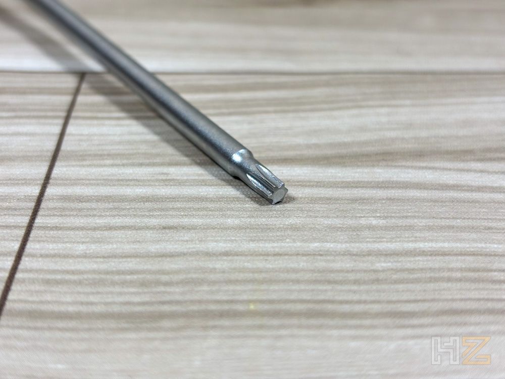 Primer plano de la punta de un destornillador tipo Torx del kit Noctua NL-LC1 apoyado sobre una superficie de madera clara.