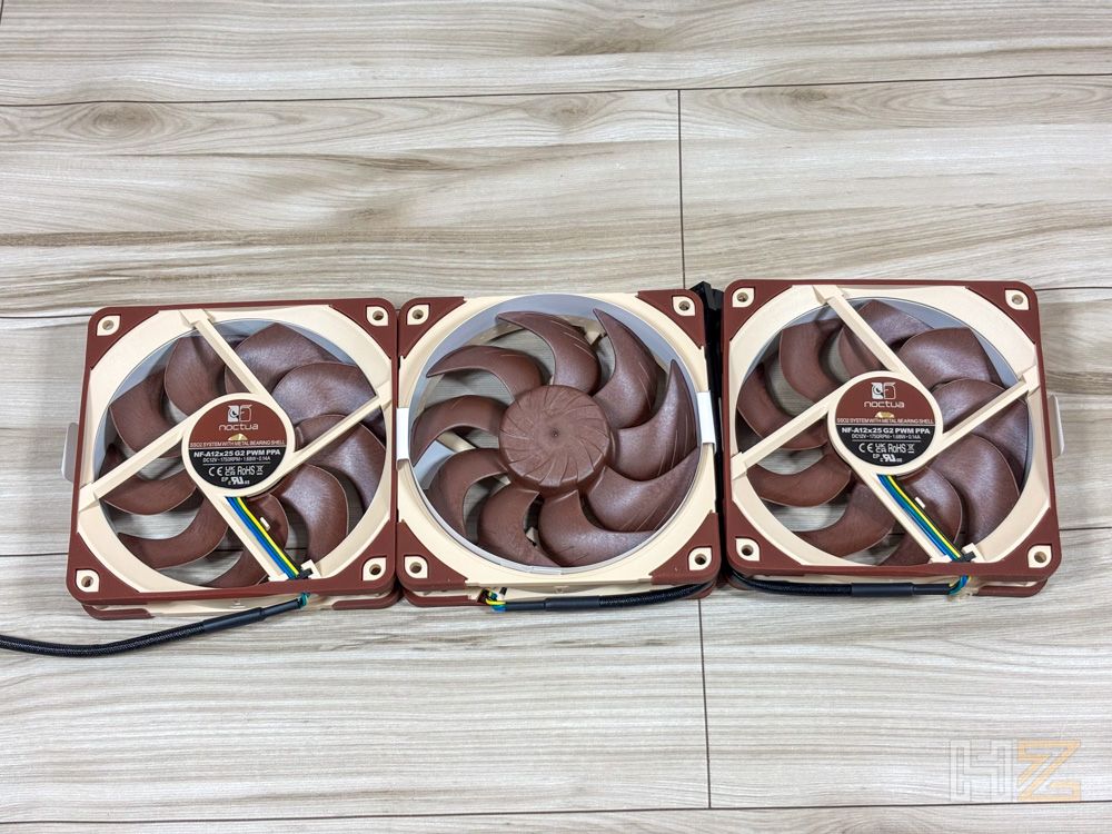 Tres ventiladores Noctua NL-LC1 colocados en fila sobre una superficie de madera clara.