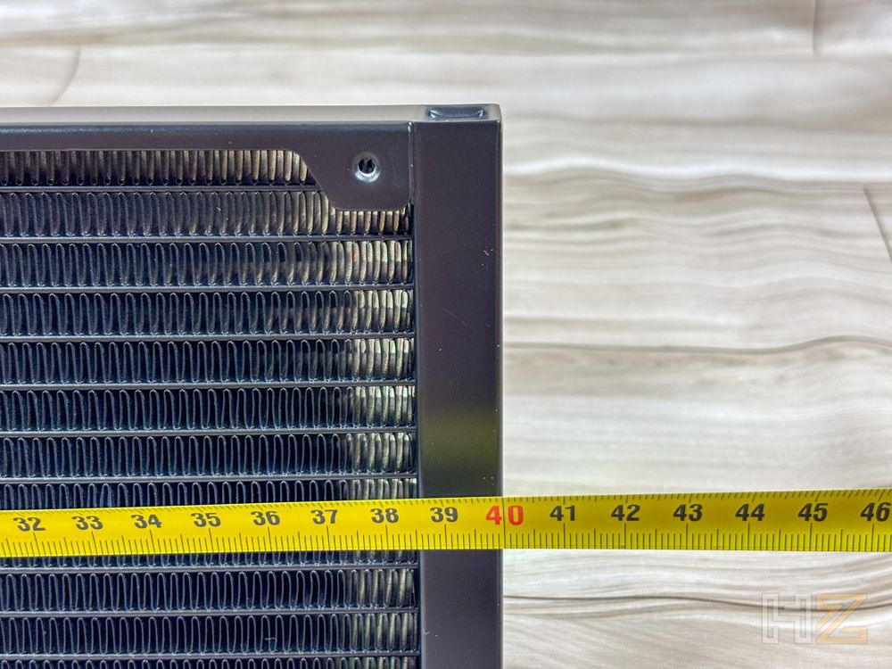 Medición con cinta métrica de la longitud de un radiador Noctua NL-LC1 sobre una mesa de madera.