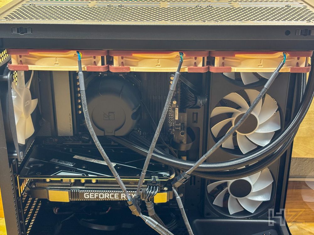 Interior de un ordenador con tres ventiladores Noctua NL-LC1 instalados en la parte superior del chasis y conectados mediante cables.