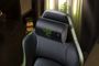 Primer plano del cojín cervical Razer Clio X instalado en el reposacabezas de una silla gaming negra con costuras verdes.