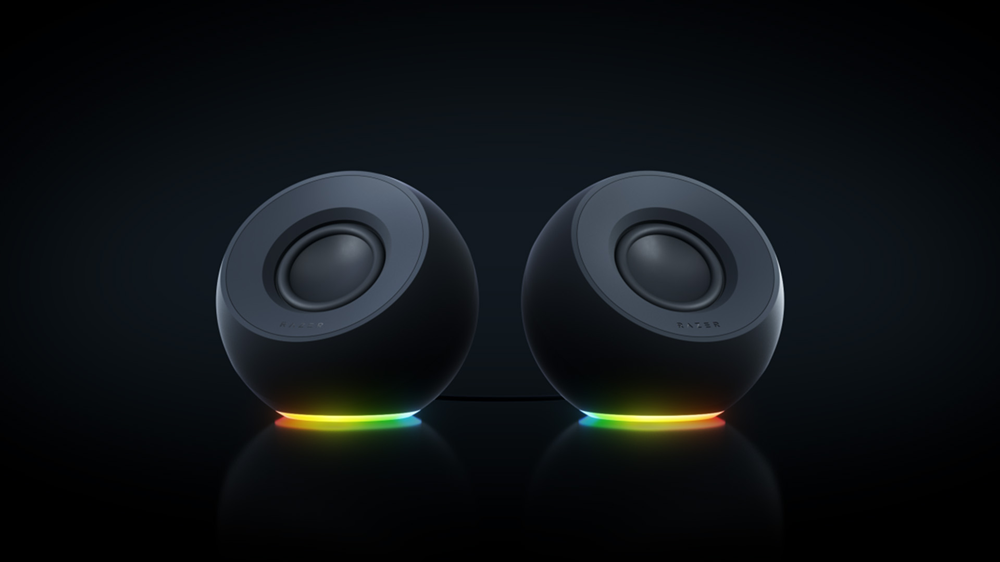 Pareja de altavoces Razer Mako X con forma esférica e iluminación RGB en la base sobre un fondo oscuro.