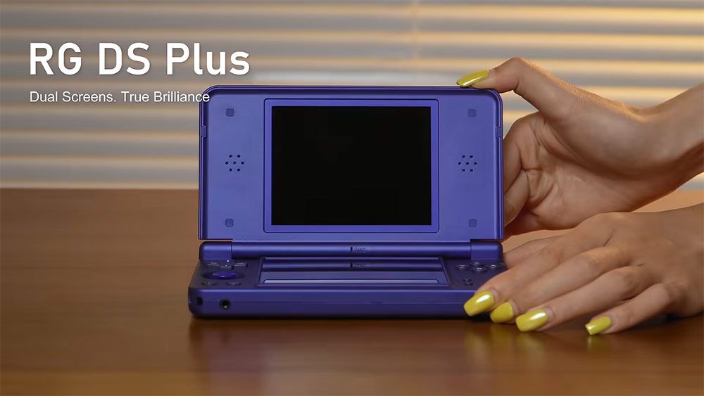 Consola portátil Anbernic RG DS Plus de color azul marino con diseño de doble pantalla abierta sobre una mesa.