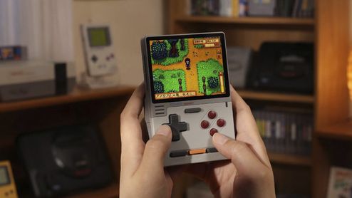 Primer plano de una consola portátil KONKR Pocket Block en las manos de un usuario ejecutando un juego de estética retro.