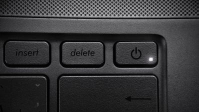 Detalle de la tecla Delete en el teclado de un ordenador portátil junto al botón de encendido.
