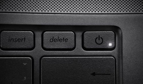 Detalle de la tecla Delete en el teclado de un ordenador portátil junto al botón de encendido.