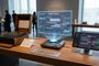 Exposición en un museo comparando una máquina Enigma original con una interfaz proyectada de ChatGPT Astra.