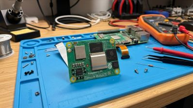 Placa Raspberry Pi Compute Module 5 sobre una alfombra de trabajo azul en un taller de electrónica.