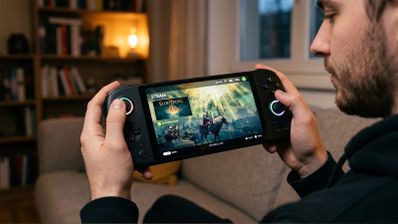 Primer plano de una persona sosteniendo una consola portátil con SteamOS mostrando el juego Elden Ring en pantalla.