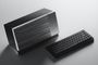 Caja externa para GPU WICI One junto a un teclado mecánico compacto sobre una superficie gris.