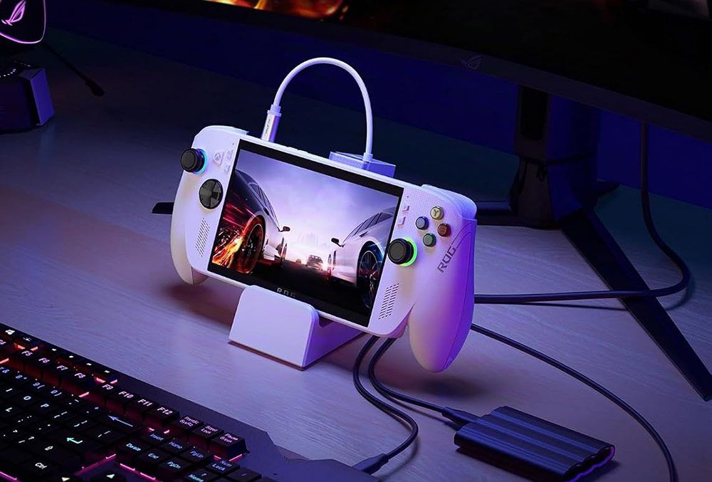 Consola portátil blanca conectada a una estación de carga JSAUX en un escritorio gaming.