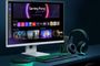 LG Smart Monitor en un escritorio con interfaz de Gaming Portal activa, teclado y auriculares con iluminación verde.