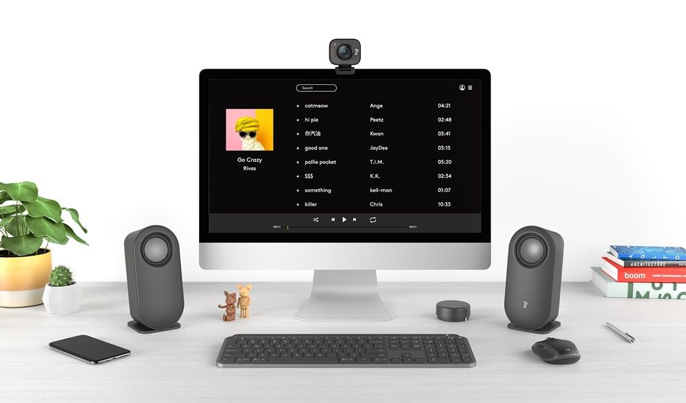 Configuración de escritorio con los altavoces Logitech z407 junto a un monitor, teclado, ratón y webcam.