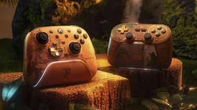 Dos mandos inalámbricos de la marca 8bitdo personalizados con motivos de la saga Tomb Raider colocados sobre troncos en un entorno selvático.