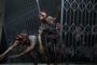 Criaturas infectadas con deformaciones en la cabeza avanzan en grupo tras una valla metálica rota en una escena de The Last of Us Part II.