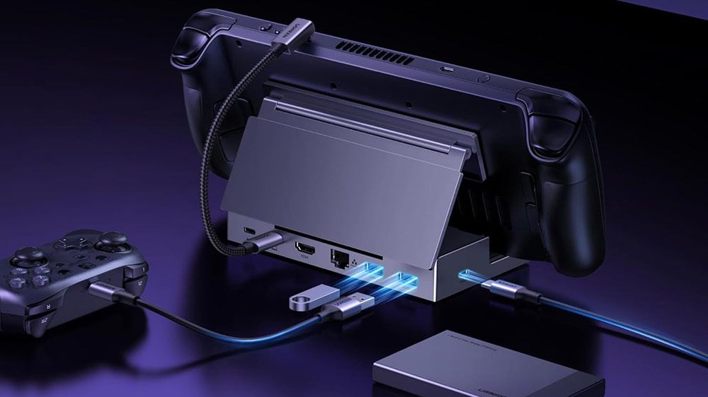 Consola portátil Steam Deck conectada a una estación de acoplamiento Ugreen con varios cables y periféricos conectados en la parte trasera.
