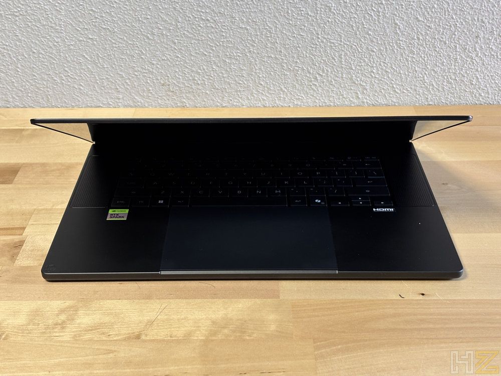 Ordenador portátil ASUS ProArt P16 H7607 parcialmente abierto sobre una mesa de madera.